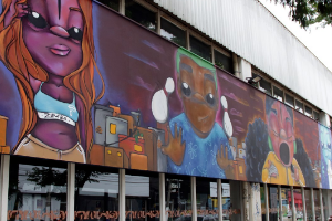 Fachada de edificio com grafitti representando jovens de diferentes estilos